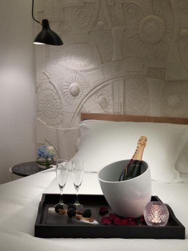 a tray with a bottle of wine and two glasses on a bed at H10 Atlantic Sunset Horizons Collection in Adeje