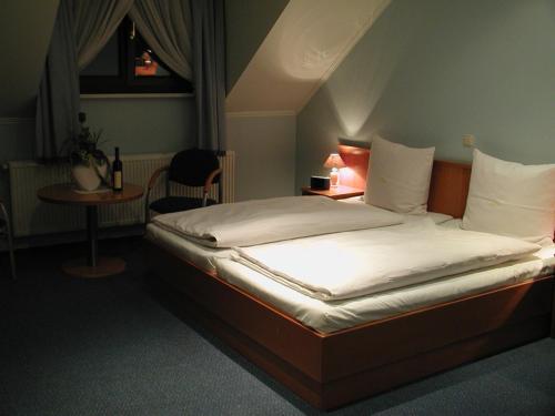 a large bed in a room with a table at Hotel Restauracja Tawerna Gliwice in Gliwice