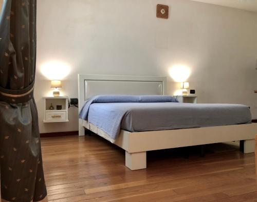 a bedroom with a bed and two lamps on two tables at Villamoreno in Merlara