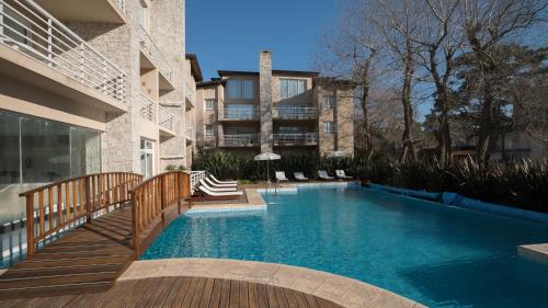 a swimming pool in front of a building at Departamentos Sea Point By D&G in Carilo