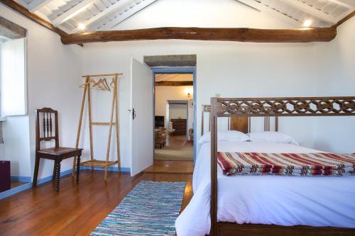 a bedroom with a bed and a chair in a room at Casa Rotas a Nordeste in Nordeste