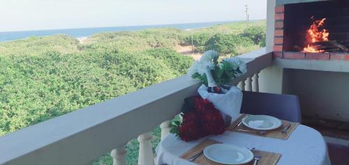 a table on a balcony with a fire place at Go Wild Beach Resort in Xai-Xai