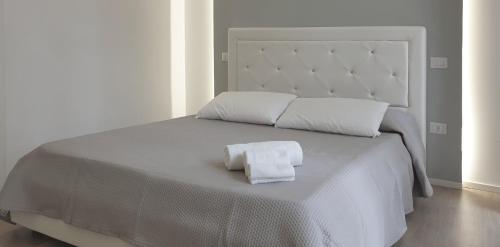 a white bed with two towels on top of it at Space Apartment in Cagliari