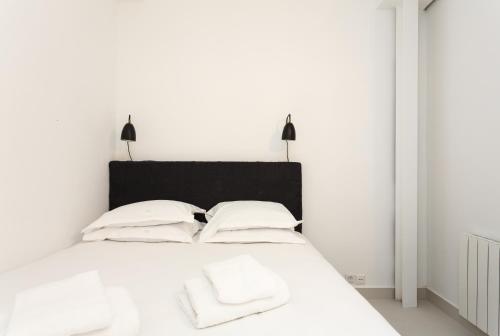 - une chambre avec un lit blanc et 2 oreillers blancs dans l'établissement Habitat Parisien - 1BR-1BA for 4 - Marais Bastille, à Paris