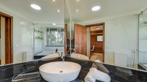 a bathroom with a sink and a large mirror at Ananda Pousada in Pirenópolis