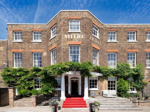 キングストン・アポン・テムズにあるThe Mitre, Hampton Courtの赤絨毯の入口のある古いレンガ造りの建物