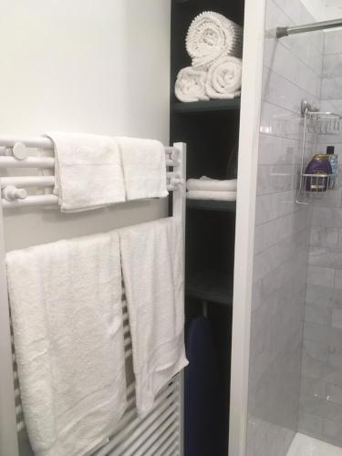 a bathroom with white towels and a shower at Oceanspray Hideaway in North Saanich