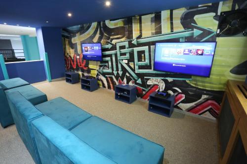 a living room with a blue couch and a mural at Hotel Palisad in Zlatibor