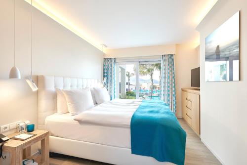 a bedroom with a large white bed and a window at 7Pines Resort Ibiza, part of Destination by Hyatt in San Jose