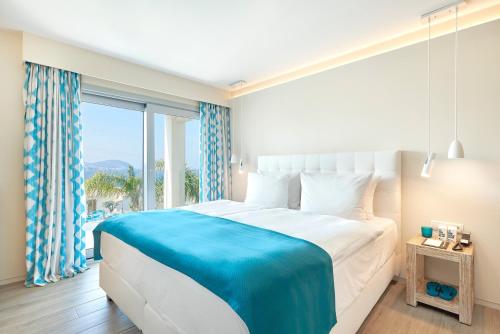 a bedroom with a large bed and a large window at 7Pines Resort Ibiza, part of Destination by Hyatt in San Jose