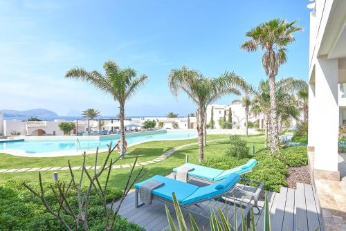 a villa with a pool and palm trees at 7Pines Resort Ibiza, part of Destination by Hyatt in San Jose