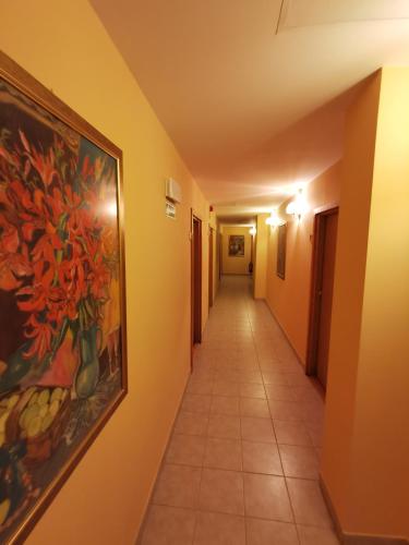 a hallway with a painting of flowers on the wall at Hotel TERESITA in Kraków