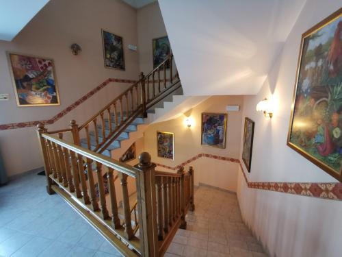 a staircase in a house with paintings on the walls at Hotel TERESITA in Kraków