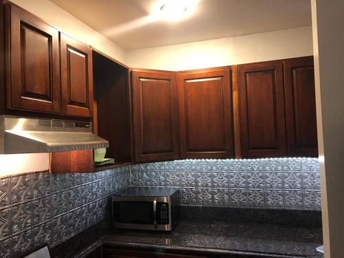 a kitchen with wooden cabinets and a microwave at Brooklyn's Finest - Cozy 2 Bedroom in Brooklyn