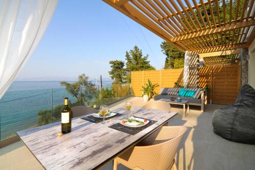 a wooden table with a bottle of wine on a patio at Casa del Mar in Mpoukaris