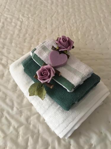 a stack of towels with roses on a bed at Violamare in Savona