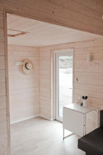a white room with a window and a table at Raceway Baltic cabins in Silakrogs