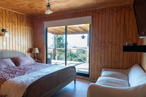 卡斯特羅的住宿－Parque pomponal，一间卧室设有一张床和一个滑动玻璃门