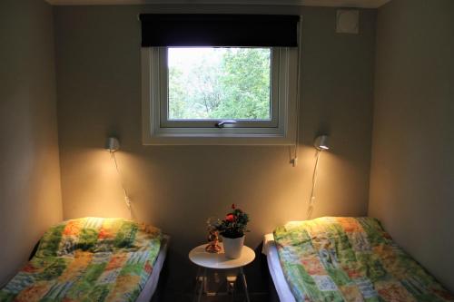 two beds in a room with a window at Naturnära STUGA ULLARED in Ullared
