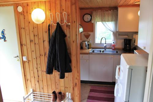 cocina con pared de madera y fregadero en Naturnära STUGA ULLARED, en Ullared