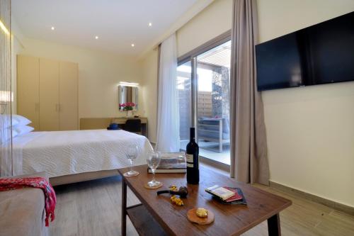 a bedroom with a bed and a table with a bottle of wine at Casa del Mar in Mpoukaris