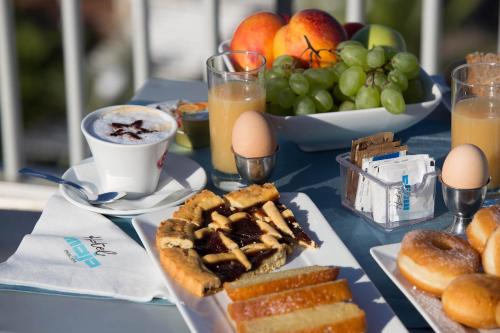 a blue table with breakfast foods and a bowl of fruit at Hotel Maja in Pescara