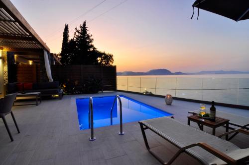 a swimming pool with a sunset in the background at Casa del Mar in Mpoukaris