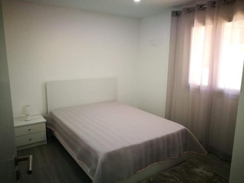 una piccola camera da letto con un letto e una finestra di Casa do Forno do Ti Correia a Macedo de Cavaleiros