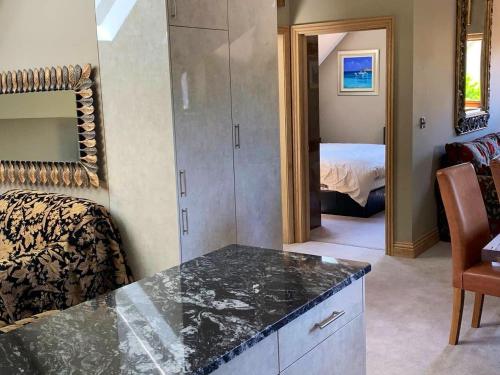 a room with a counter and a bedroom with a bed at Luxurious private coach house in Nailsea