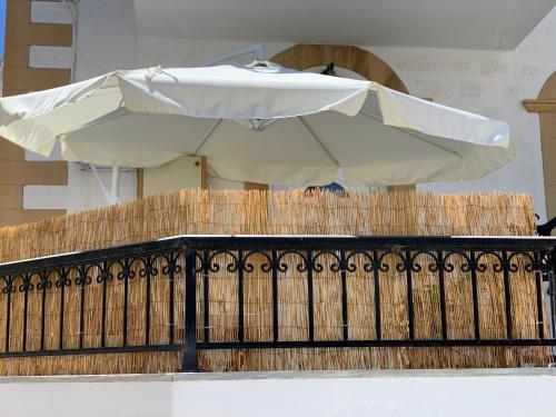 a white umbrella sitting on top of a fence at Dominik apartment in Patmos