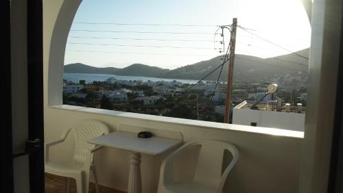 a room with a window with a table and chairs at Homer's Inn Hotel in Ios Chora