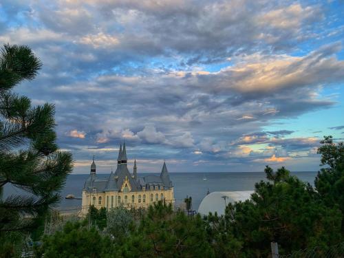 a large building with towers on the water under a cloudy sky at Room1402 in Odesa