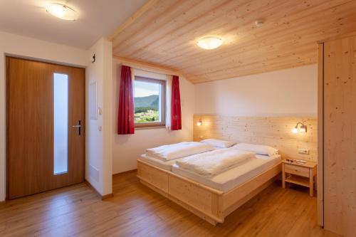 a bedroom with a large bed and a window at Residence Viktoria in Castelrotto