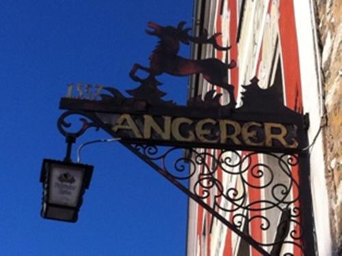 a sign on the side of a building with a lamp at Hotel Angerer in Vilseck