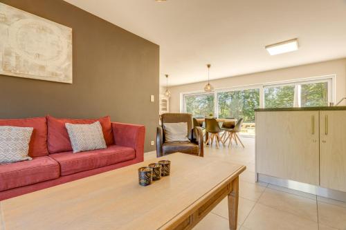 a living room with a red couch and a table at Maison LoKaKo in Waimes