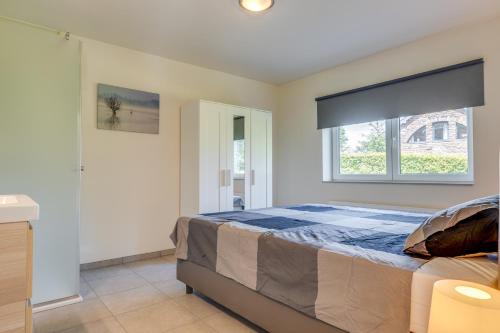 a bedroom with a large bed and a window at Maison LoKaKo in Waimes