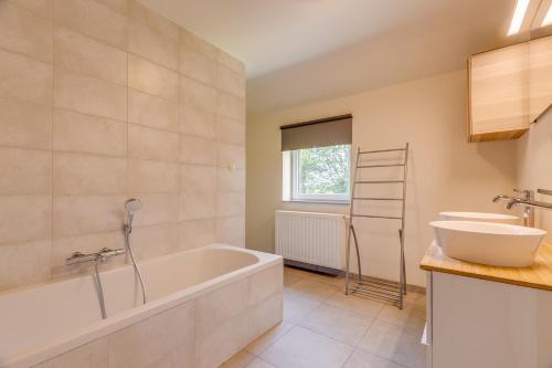 a bathroom with a tub and a sink at Maison LoKaKo in Waimes
