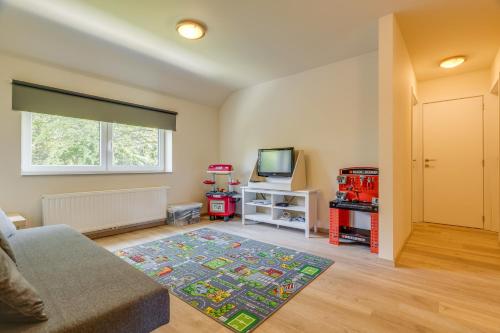 a living room with a couch and a television at Maison LoKaKo in Waimes