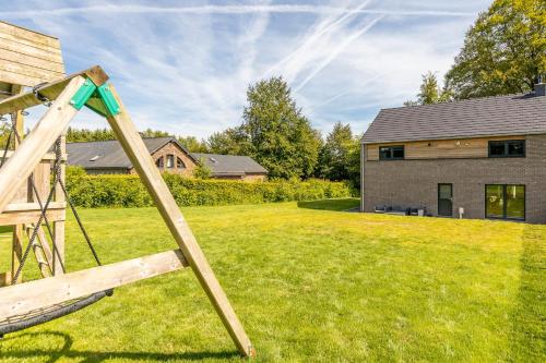 a wooden swing in the yard of a house at Maison LoKaKo in Waimes