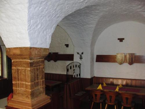 a dining room with a table and a stone pillar at Hotel Angerer in Vilseck