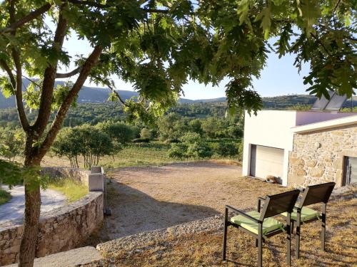 a bench sitting under a tree next to a building at Quinta dos Carvalhais - Serra da Estrela in Fornos de Algodres