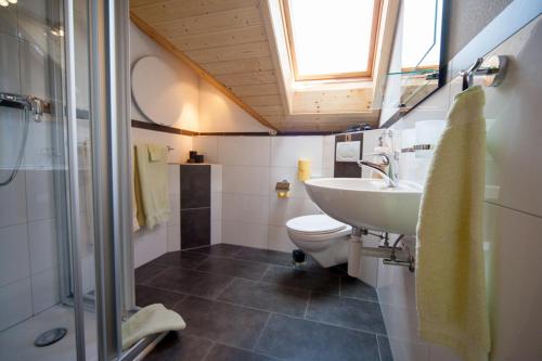 a bathroom with a sink and a toilet and a window at B&B Ferienhof am See in Willerzell