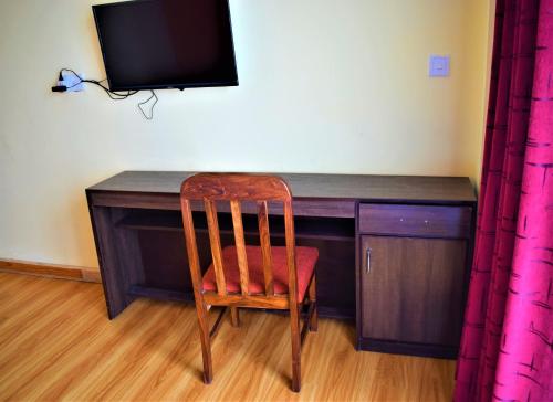 a chair sitting in front of a desk with a television at Hotel Nagarkot Inn in Nagarkot