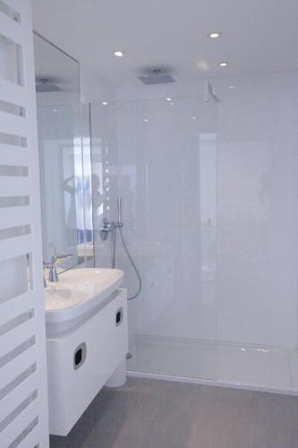 une salle de bain blanche avec un lavabo et une douche dans l'établissement Design Apartment - Pool, Large Terrace and Panoramic Views of Mediterranean, à Bandol