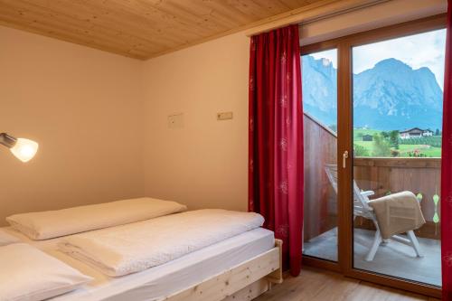 a bedroom with two beds and a window with mountains at Residence Viktoria in Castelrotto