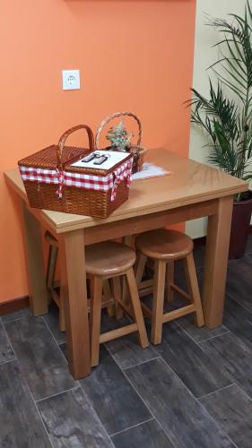 a wooden table with two baskets and two stools at Casa da Fonte in Peso da Régua