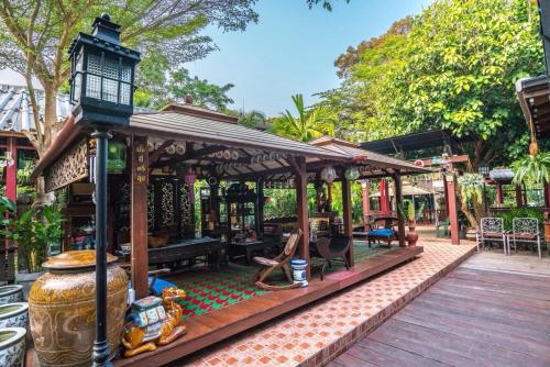 a pavilion with a table and chairs on a wooden deck at Ban Mai Vintage in Pak Chong