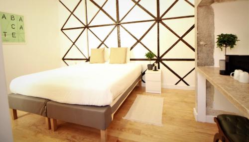 1 dormitorio con 1 cama grande con sábanas blancas en Frutaria - Lisbon Suites en Lisboa