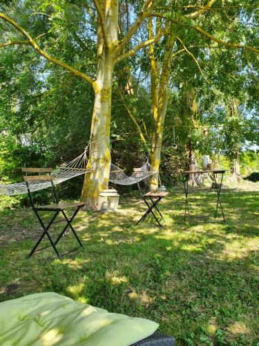 a hammock in the grass under a tree at "Au jardin sur l'eau" Hortillonnages in Amiens