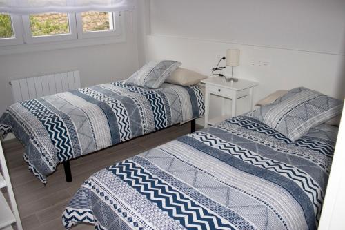 dos camas sentadas una al lado de la otra en un dormitorio en IZASKUNena Home E-BI 1190, en Getxo